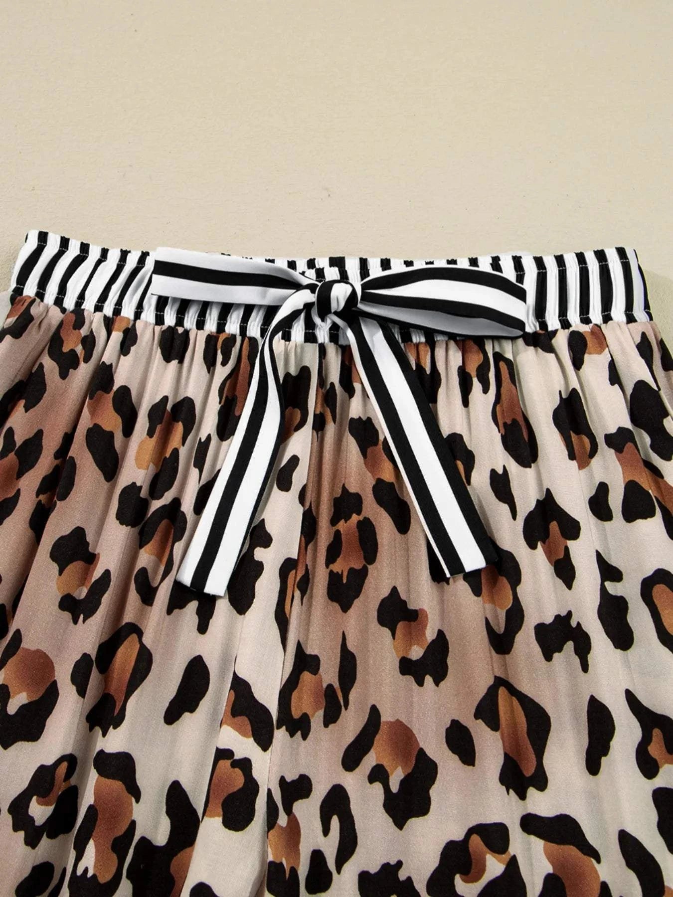 Close-up of leopard print pants with black and white striped drawstring waistband from Leopard and Striped Trim Shirt and Pants Set