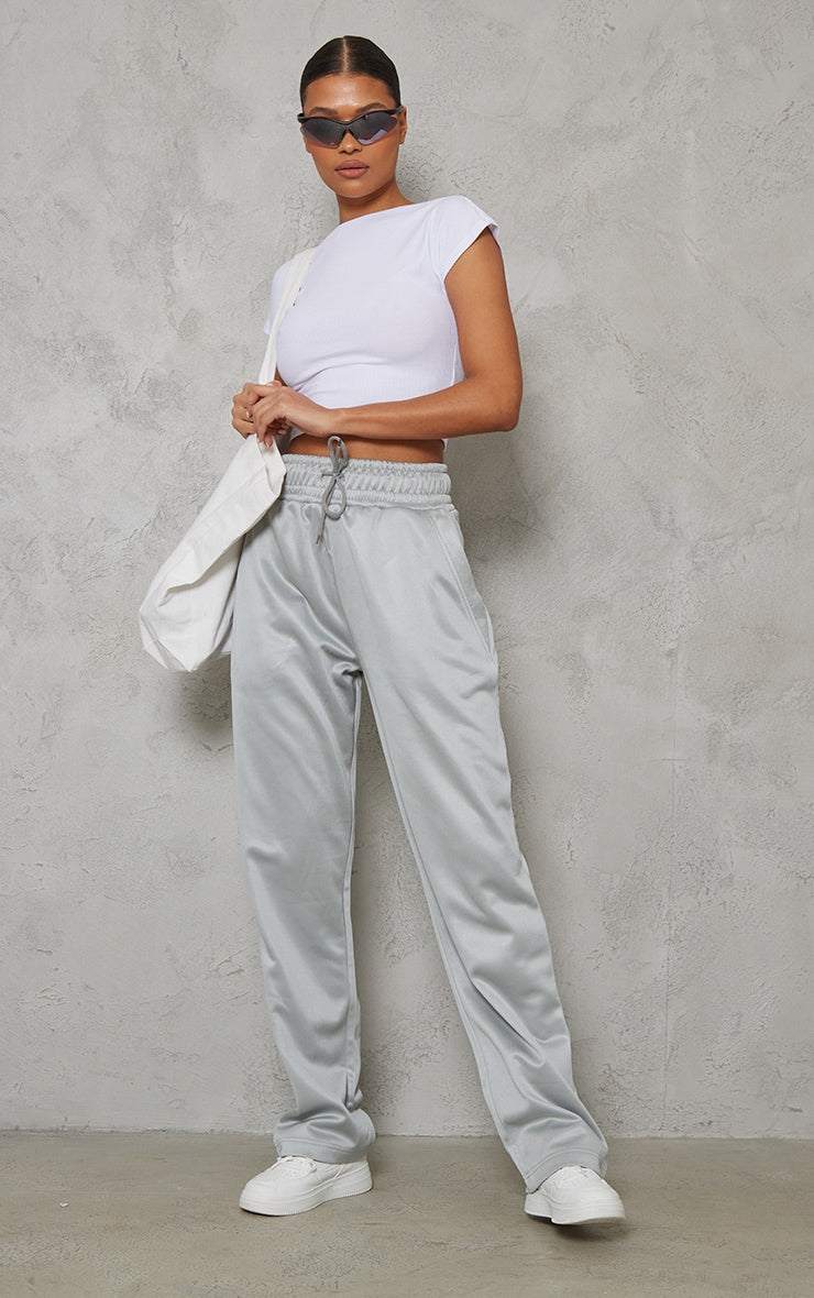 woman wearing white soft rib backless top with grey wide-leg trousers and white sneakers
