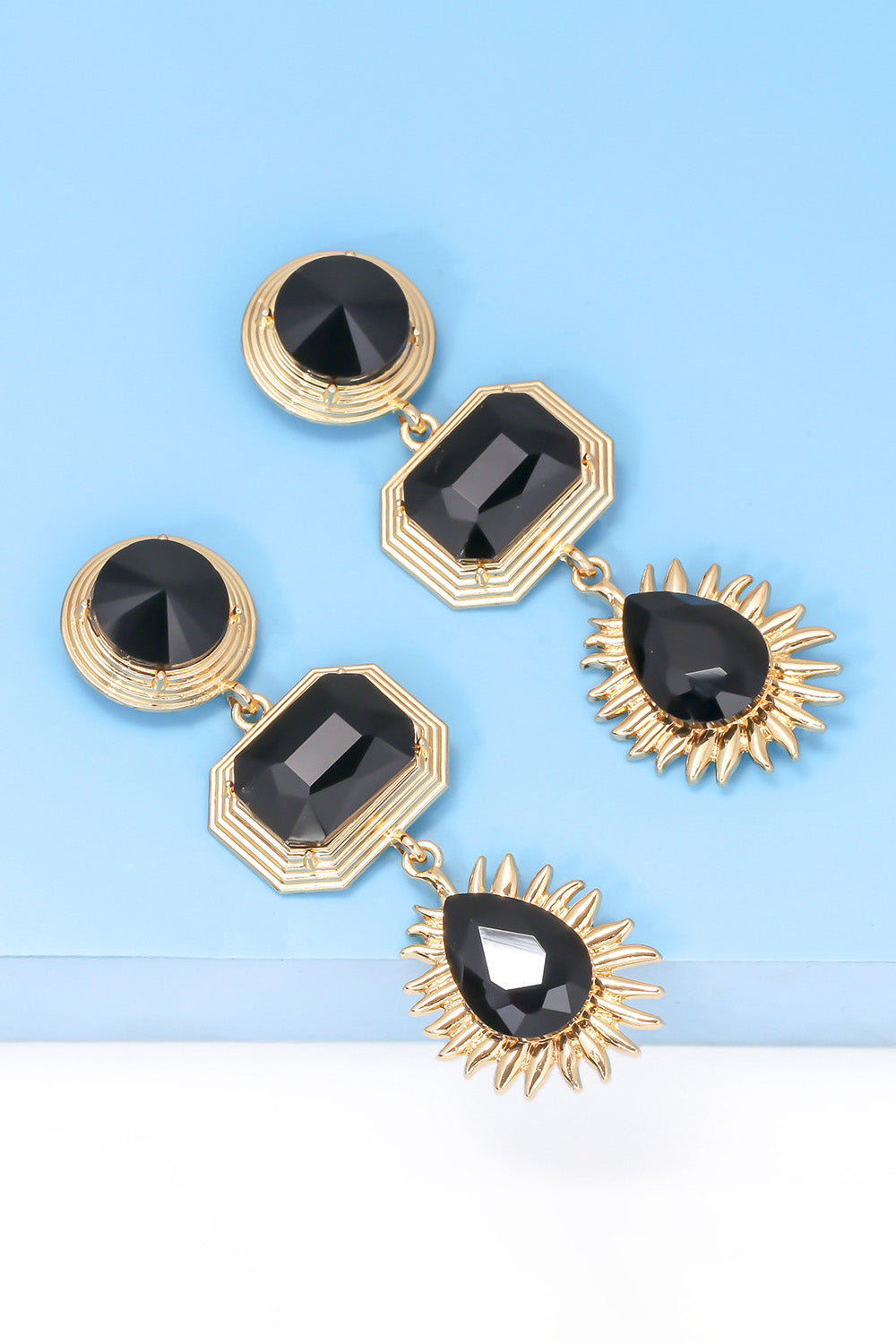 Geometrical shape zinc alloy frame glass dangle earrings with black stones on blue background