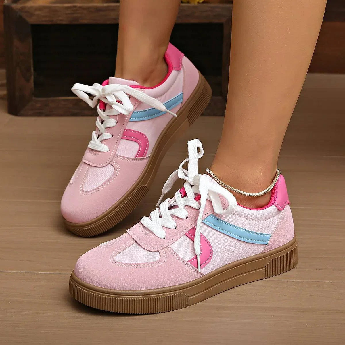 Pink and white lace up platform sneakers with blue and pink detailing and brown rubber soles