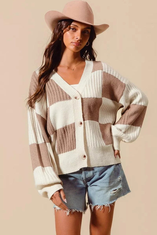 Checkered button front ribbed sweater cardigan in beige and white worn with denim shorts and beige hat