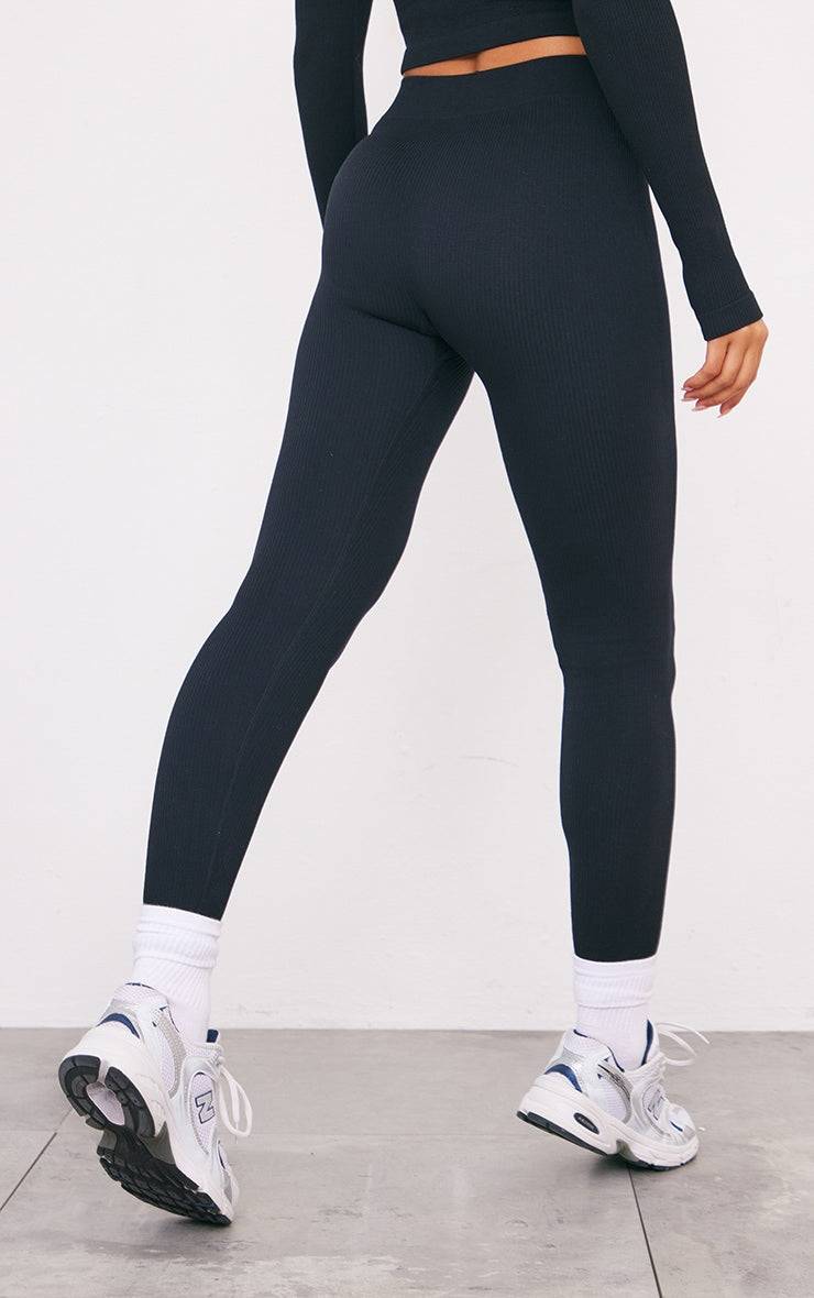 Black structured contour ribbed leggings with a high waist and slimming fit styled with white sneakers