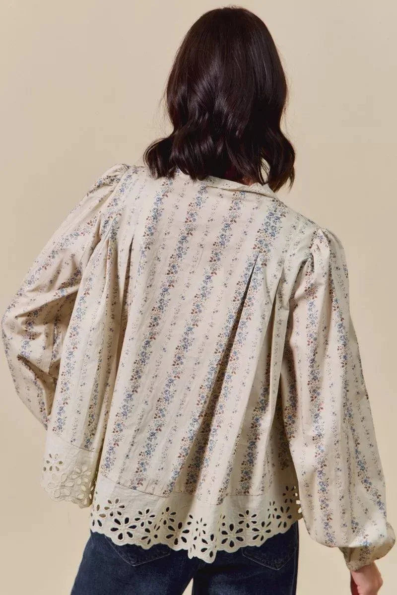 Back view of a floral print lace button-down shirt with ruffled eyelet hem and puff sleeves