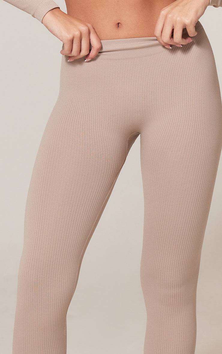Close-up of beige ribbed leggings with structured contour knit design for sculpted silhouette and comfort