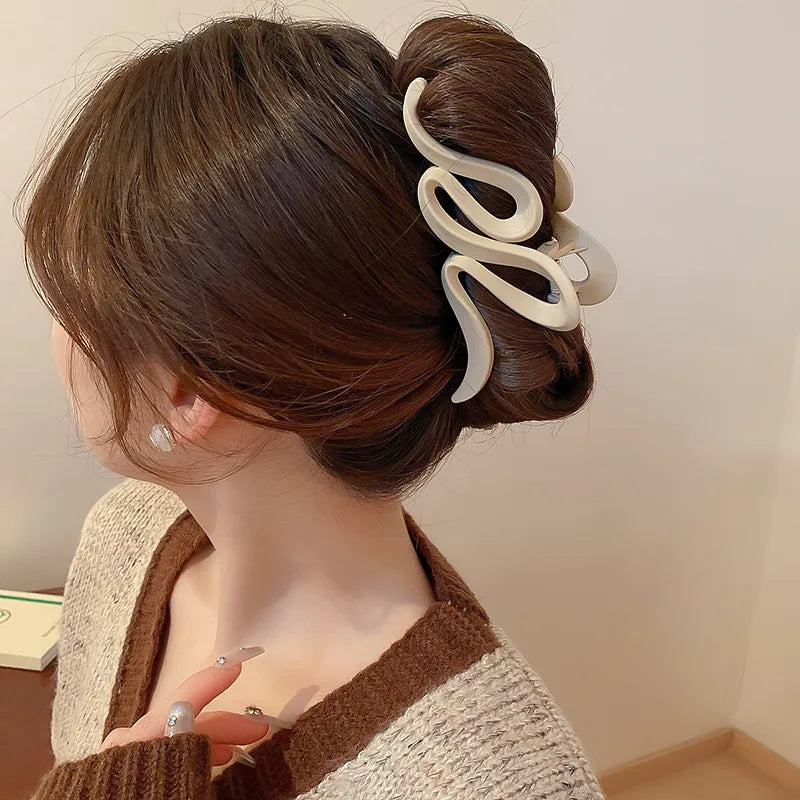 Woman wearing an alloy acrylic hair claw clip holding hair in an updo.