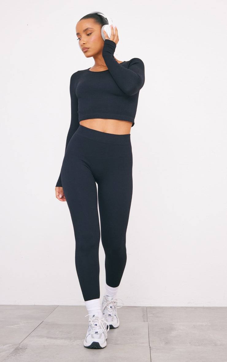 black structured contour ribbed leggings worn with black long sleeve crop top and white sneakers on model