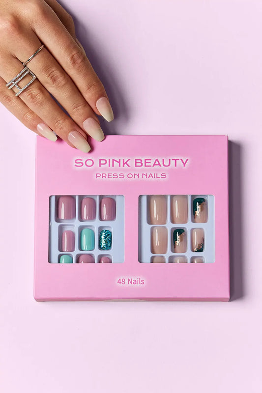 So Pink Beauty Press On Nails two-pack with 48 pieces including pink, teal, glitter, and marble designs in a pink box with hand model showing applied nails