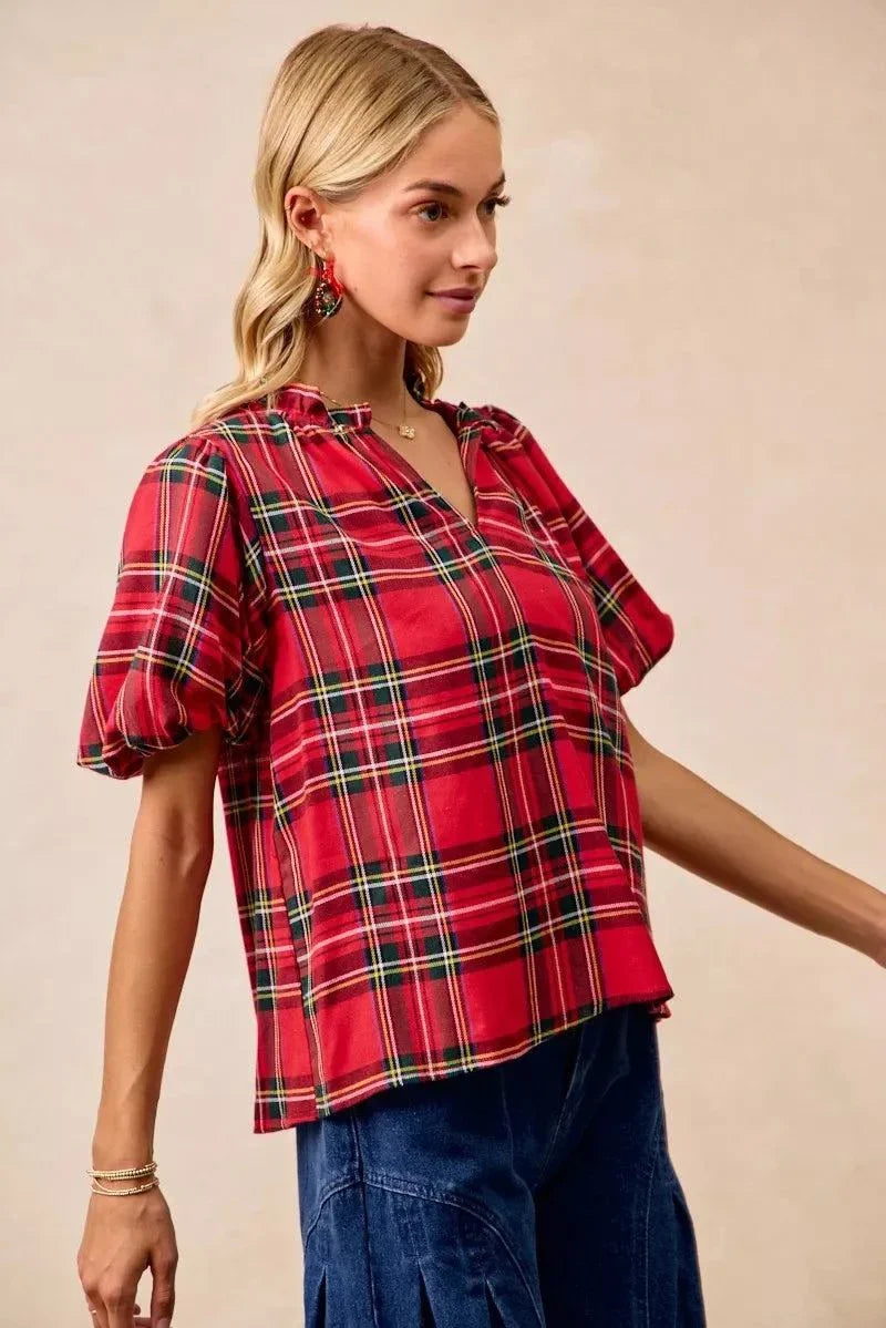 BiBi Christmas Plaid Short Sleeves Ruffled BlouseThis Christmas plaid short sleeves ruffled blouse is a festive and charming addition to your holiday wardrobe. The classic plaid pattern evokes a cheerful and cozy hChristmas plaid blouse