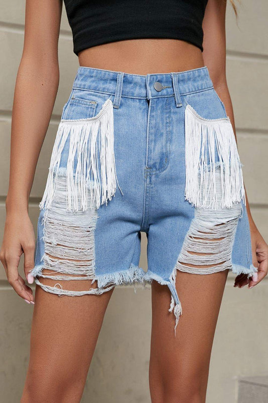 Fringe trim distressed denim shorts with large white fringe pockets and frayed hems.