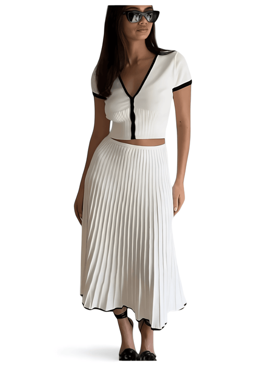 Woman wearing elegant white pleated two-piece set with black trim and sunglasses