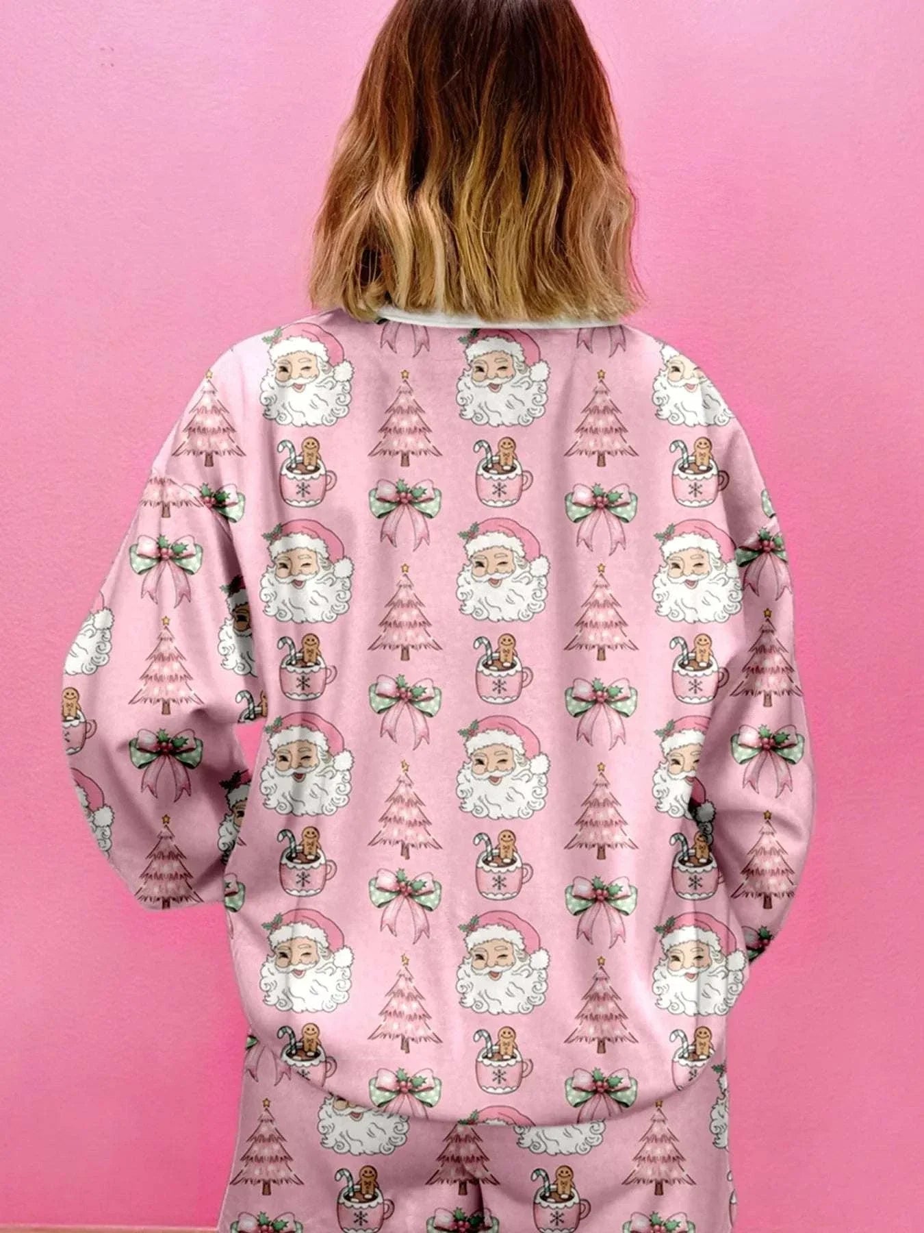 woman wearing pink Christmas Santa print round neck top and shorts lounge set from back view