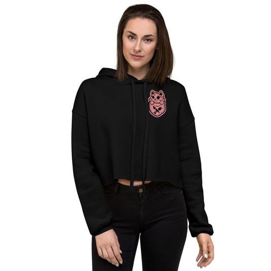 Woman wearing black Pocket Puss Crop Hoodie with pink cat graphic on chest, styled with high-waisted black pants